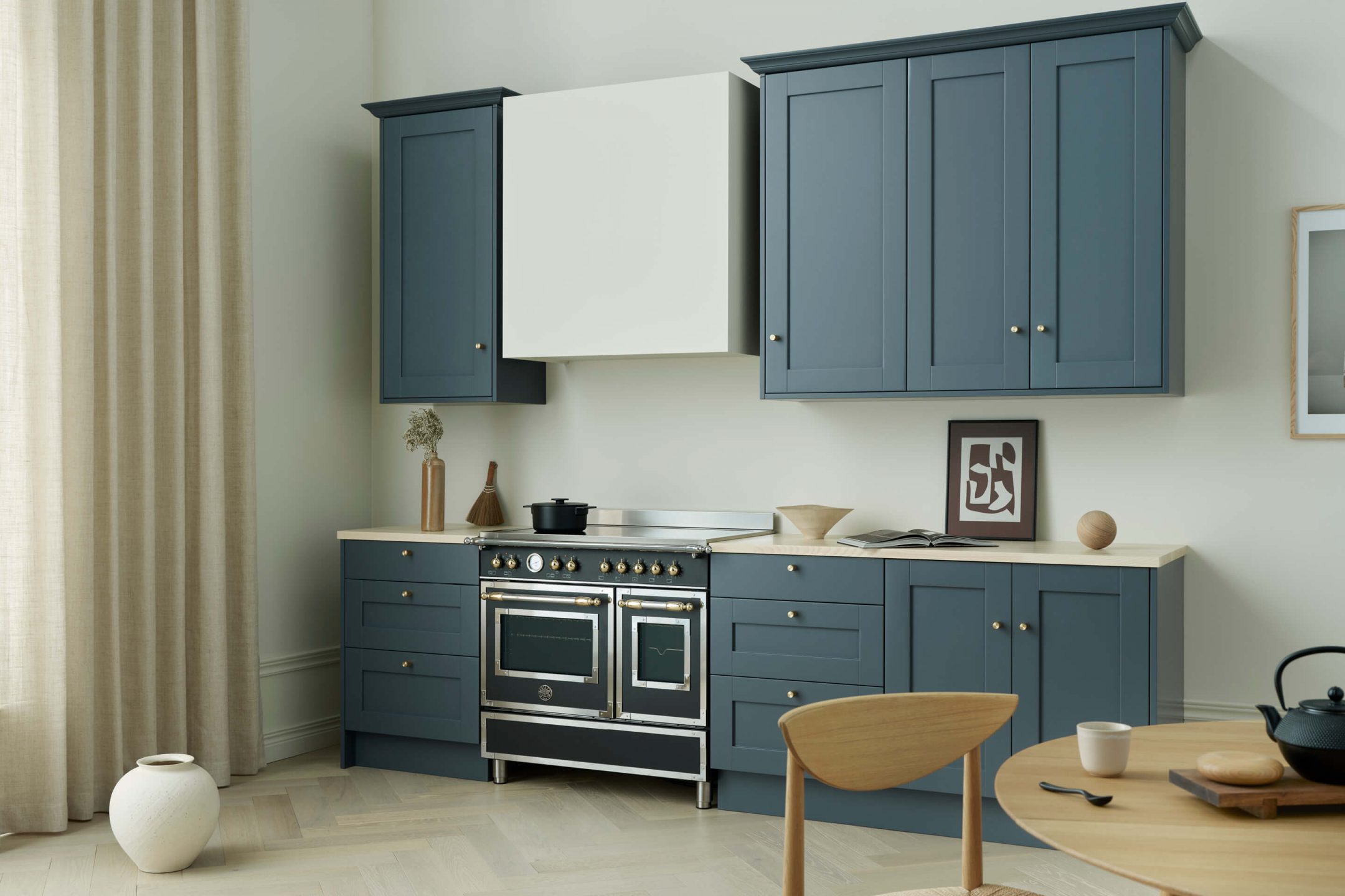 Klassiskt kök i blått med ljus bänkskiva i ask