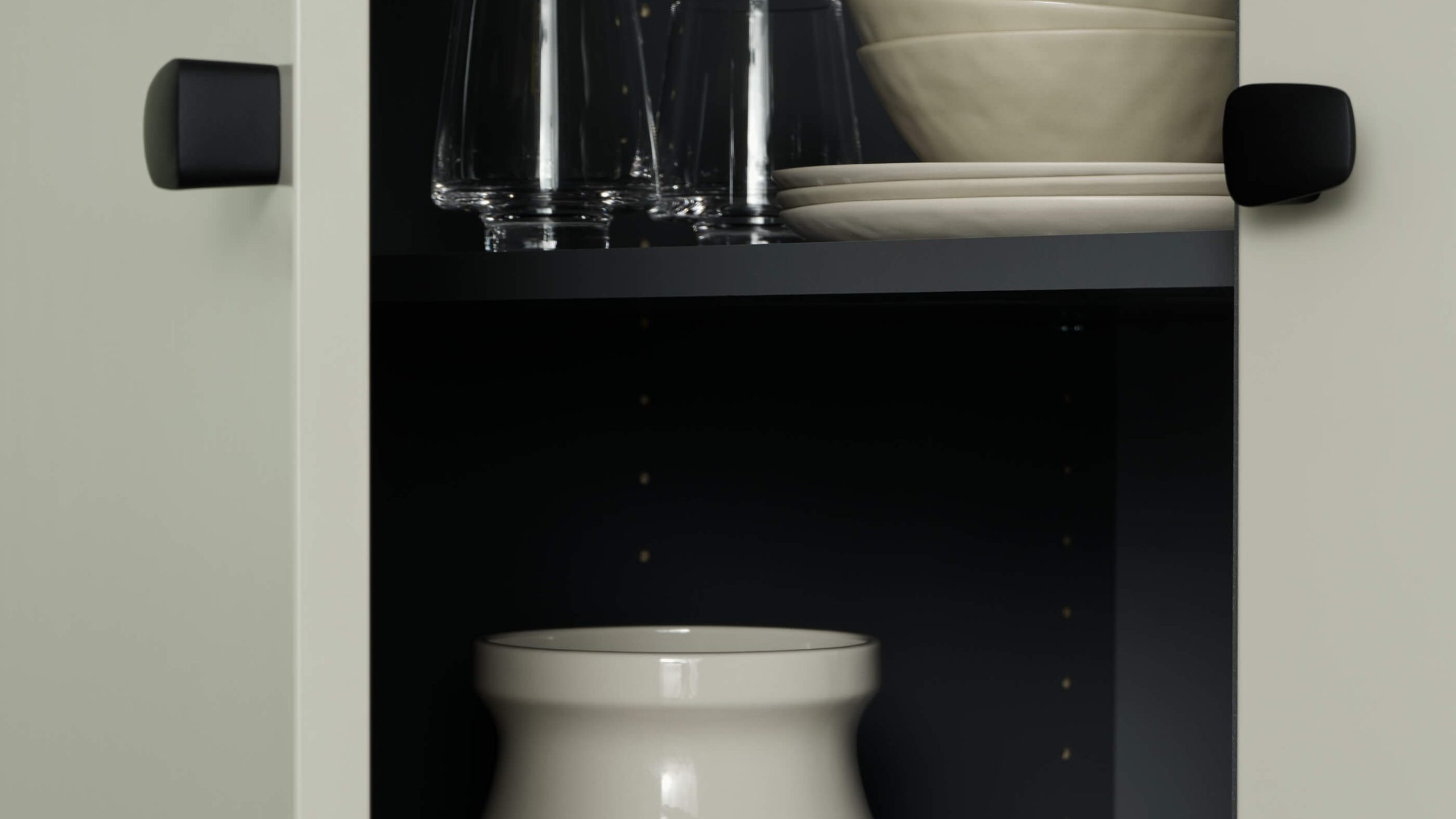 Öppet köksskåp i beige med svarta knoppar