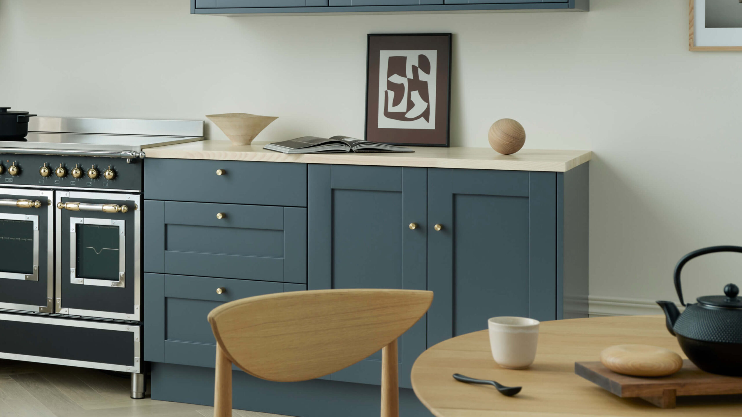 Köksluckor i blått med ljus bänkskiva och knoppar i mässing